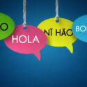 Foreign language colorful communication speech bubbles hanging from a cord over blue background