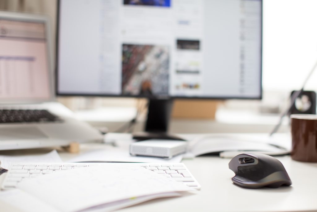 Mouse and keyboard in front of blurred out monitor