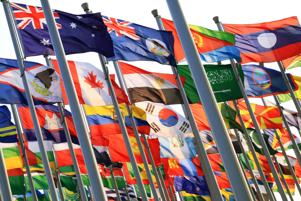 Waving international flags in blue sky