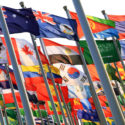 Waving international flags in blue sky