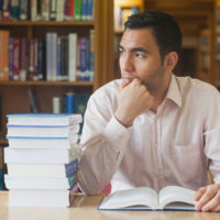 Man studying in library with books