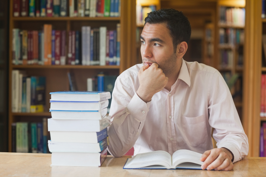 Man studying in library with books