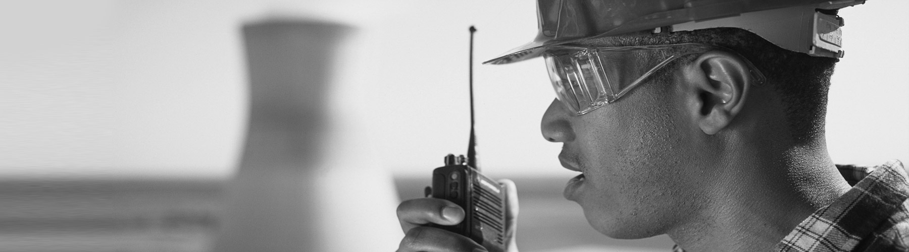black and white picture of construction worker holding radio device