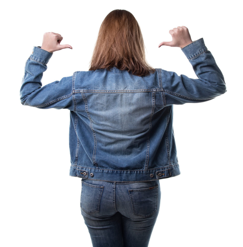 Woman wearing jeans jacket and thumbs
